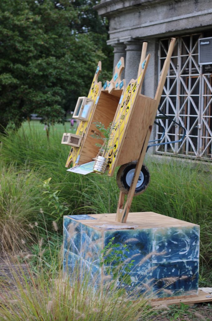 Image: Porta(til). An upside-down wheelbarrow an angle where passersby can look inside. Photo by and courtesy of Carlos Flores.